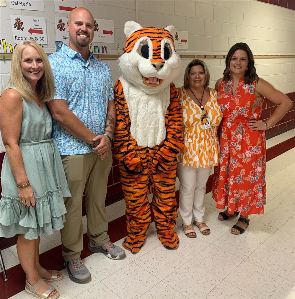 4 people standing with tiger